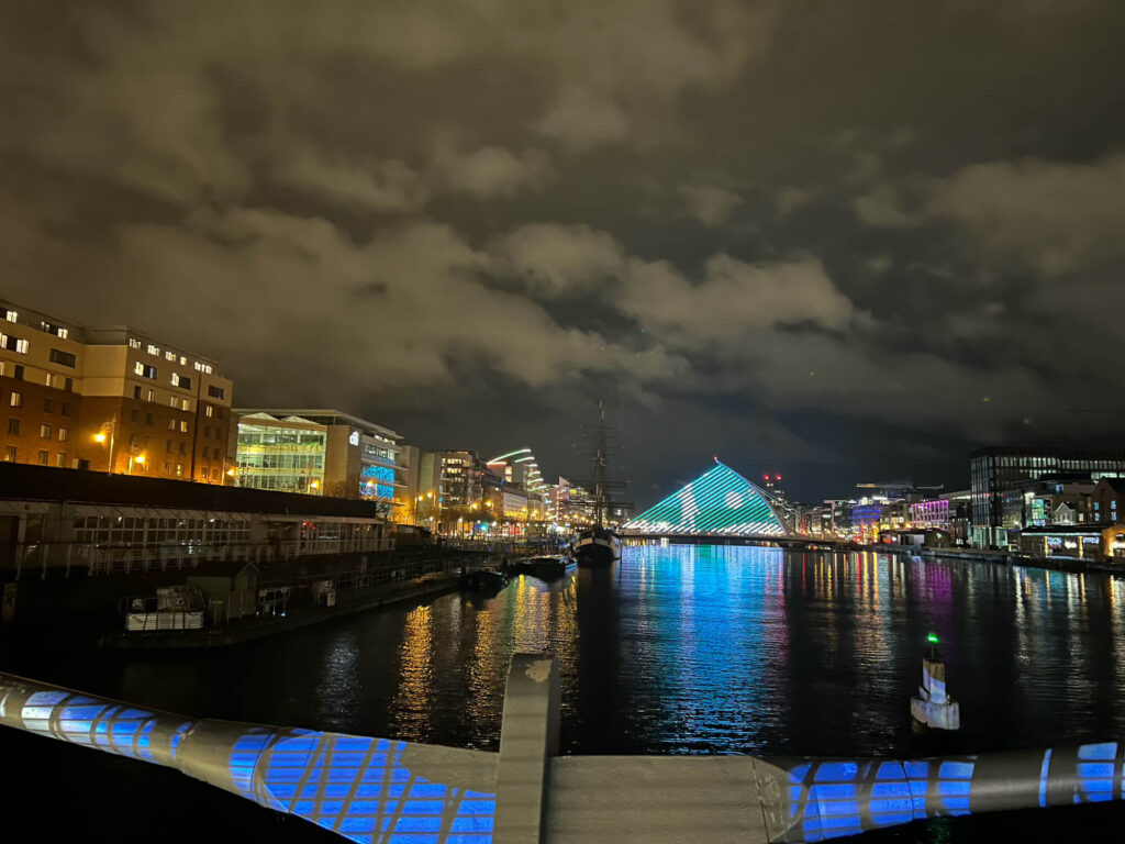 The buildings by the dock in Dublin lit up at night.