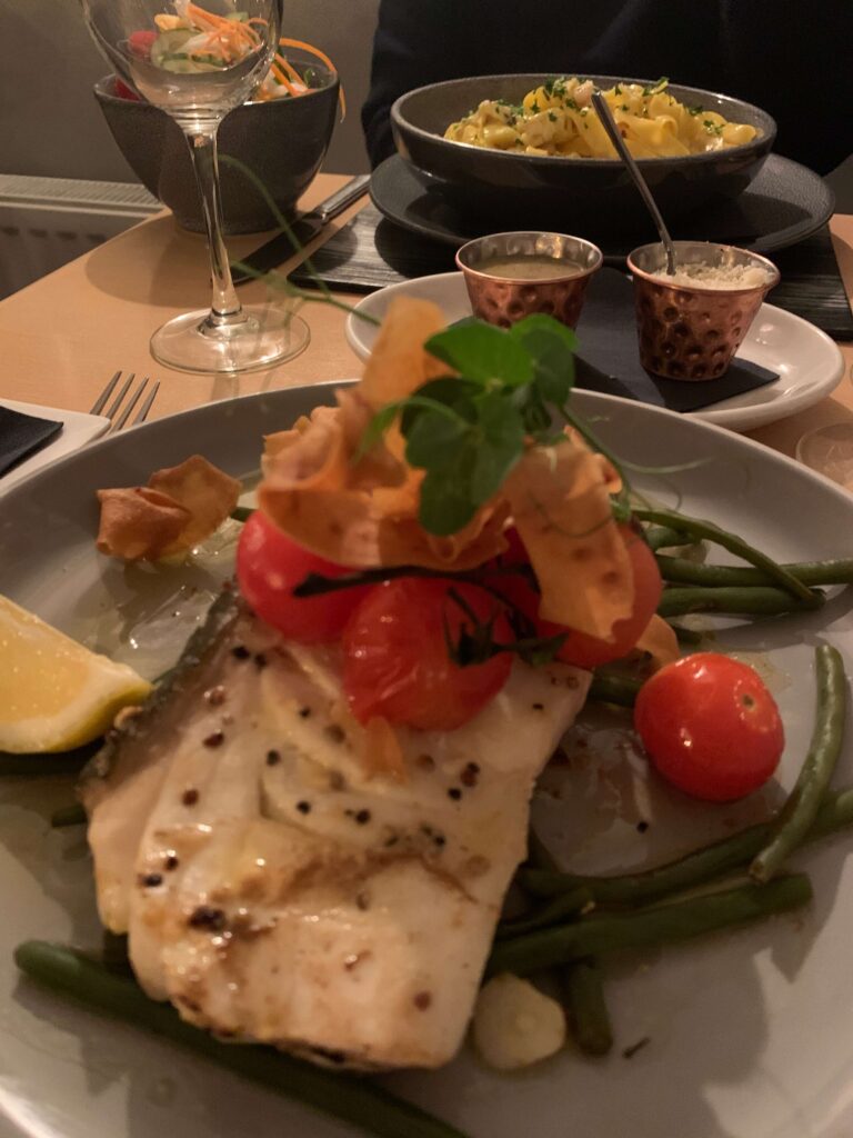 Halibut with cherry tomatoes, and lemon wedge