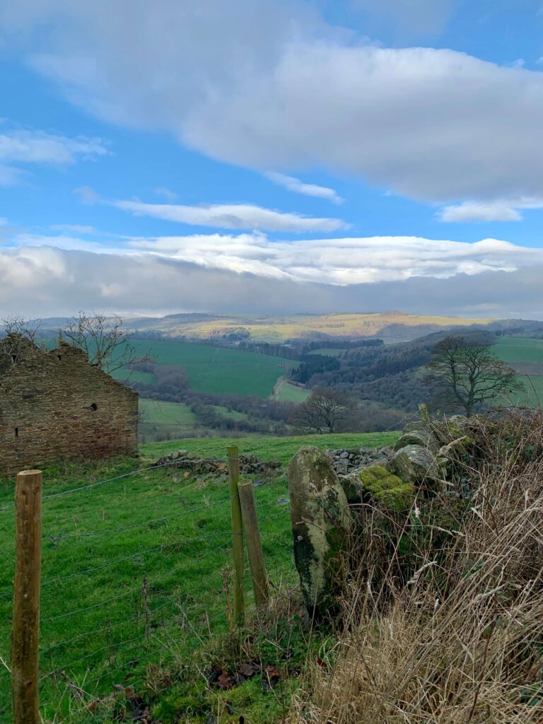 Views of the Derbyshire countryside with a farm building in the foreground