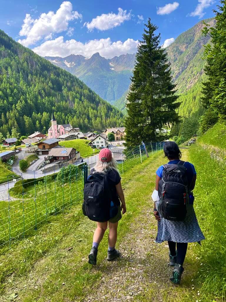 Two women walking towards a Swiss village