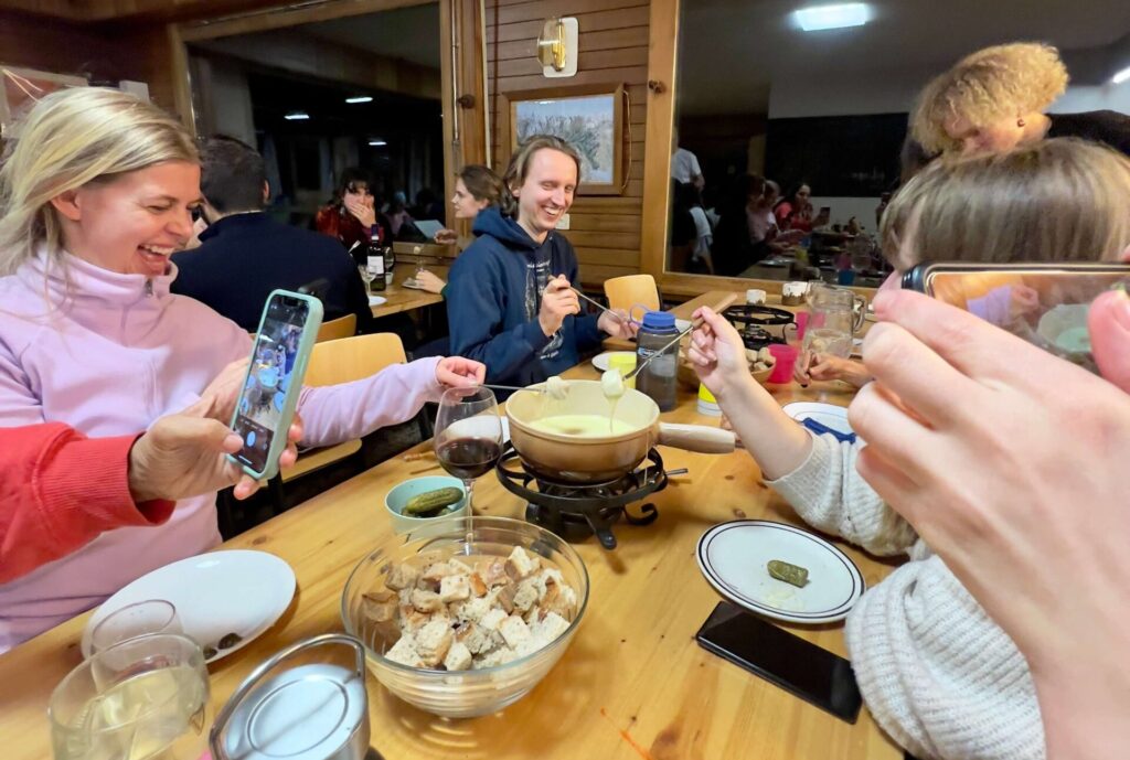 A group of travellers enjoying fondue night at the Ski Hostel.