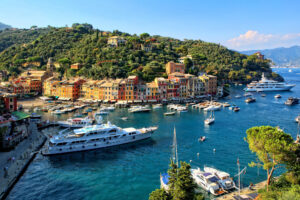 Two yachts and several smaller boats in the harbour at Portofino in Italy.
