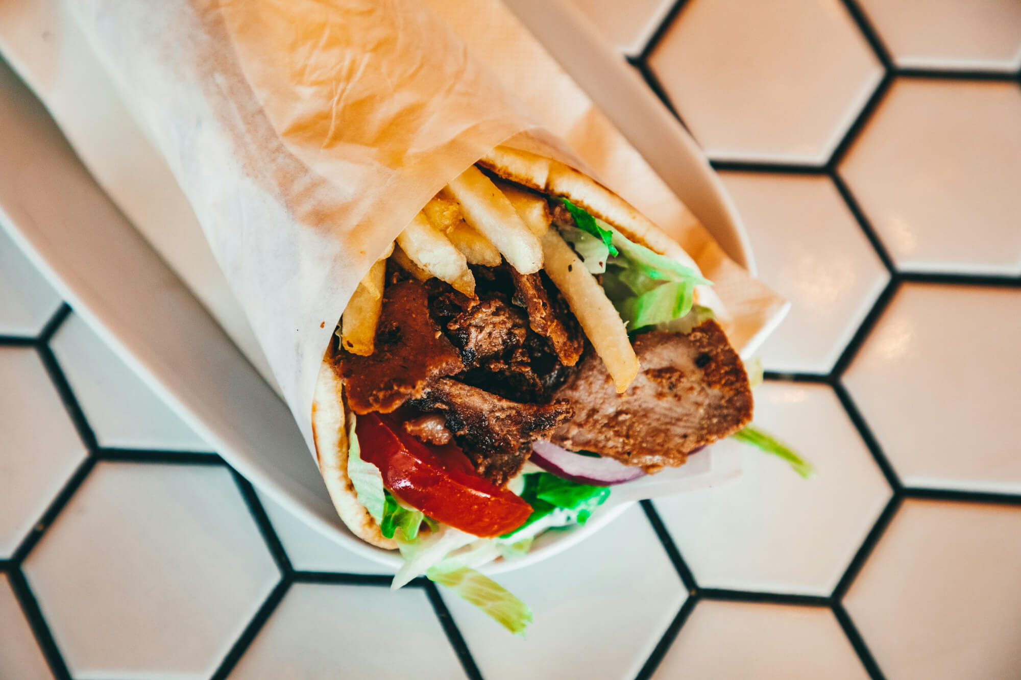 A Greek gyros kebab with meat, salad and chips.