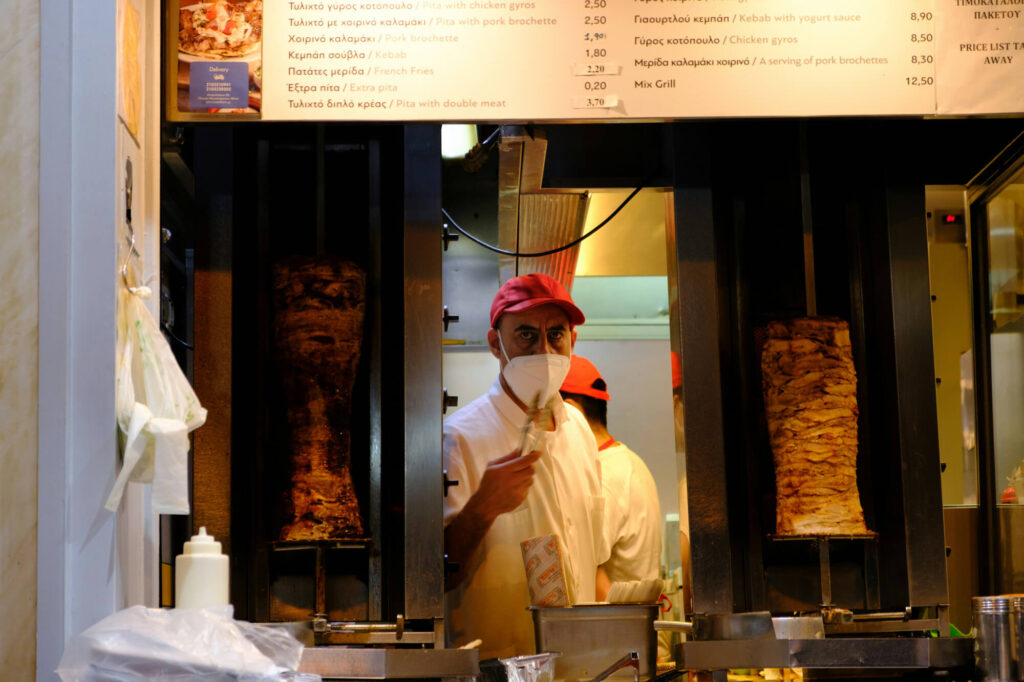 Two men working at a gyros shop in Athens.
