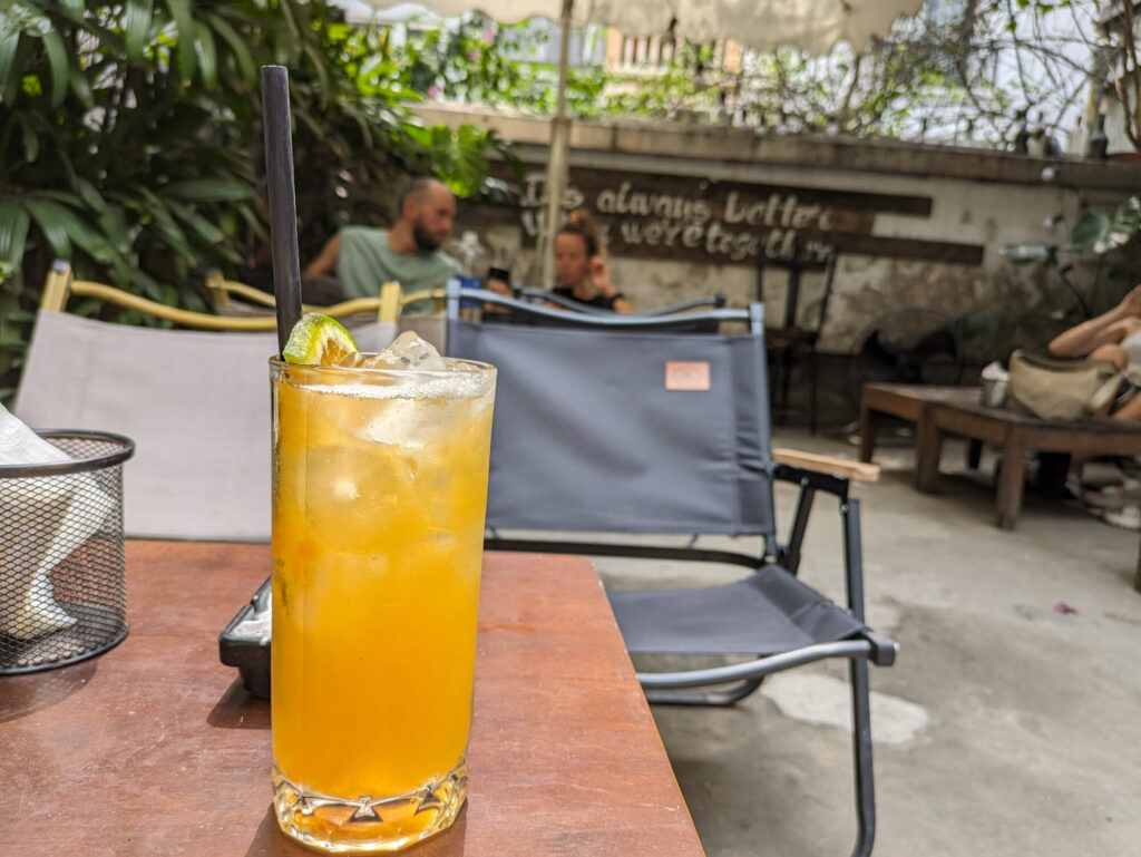 An orange drink with ice cubes on a table.