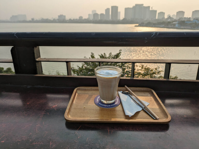 Coffee in a glass overlooking a cityscape of Hanoi.