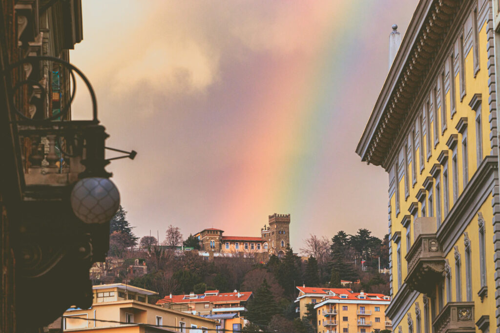 A rainbow shows over a castle in Trieste, Italy.