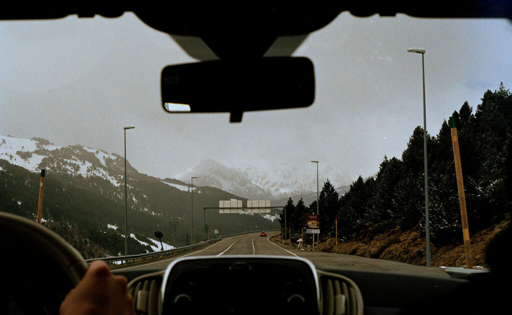 A view of snowy mountains from inside a car.