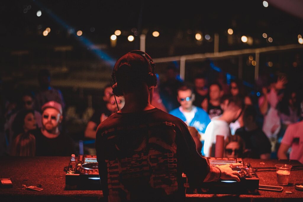 A DJ plays music to a crowded dancefloor.