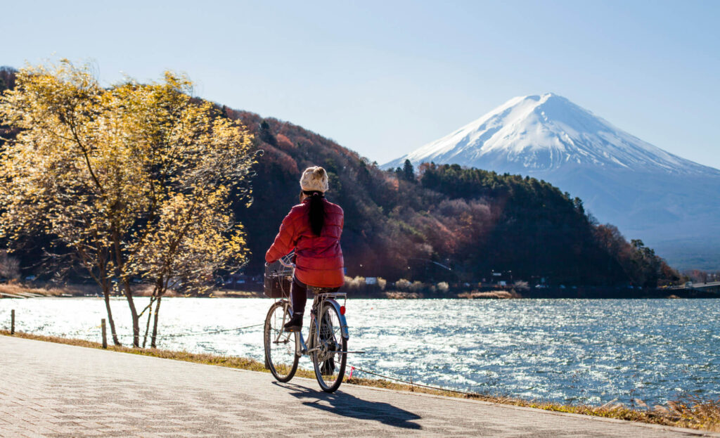 A woman cycles by Mount Fuji.