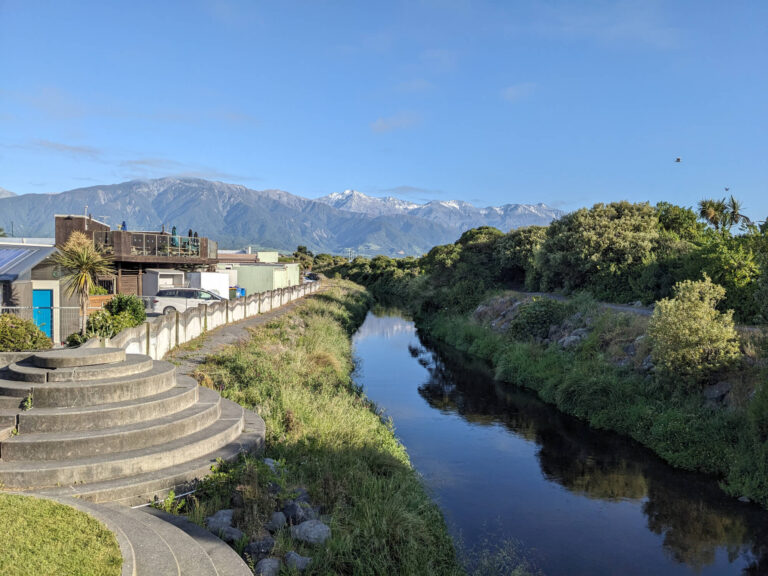 A river running through Kaikoura with mountains in the background.