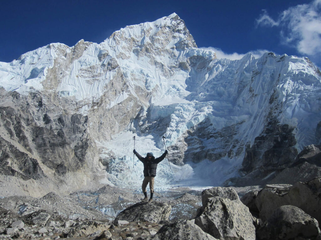 A person raising their arms up at Everest.