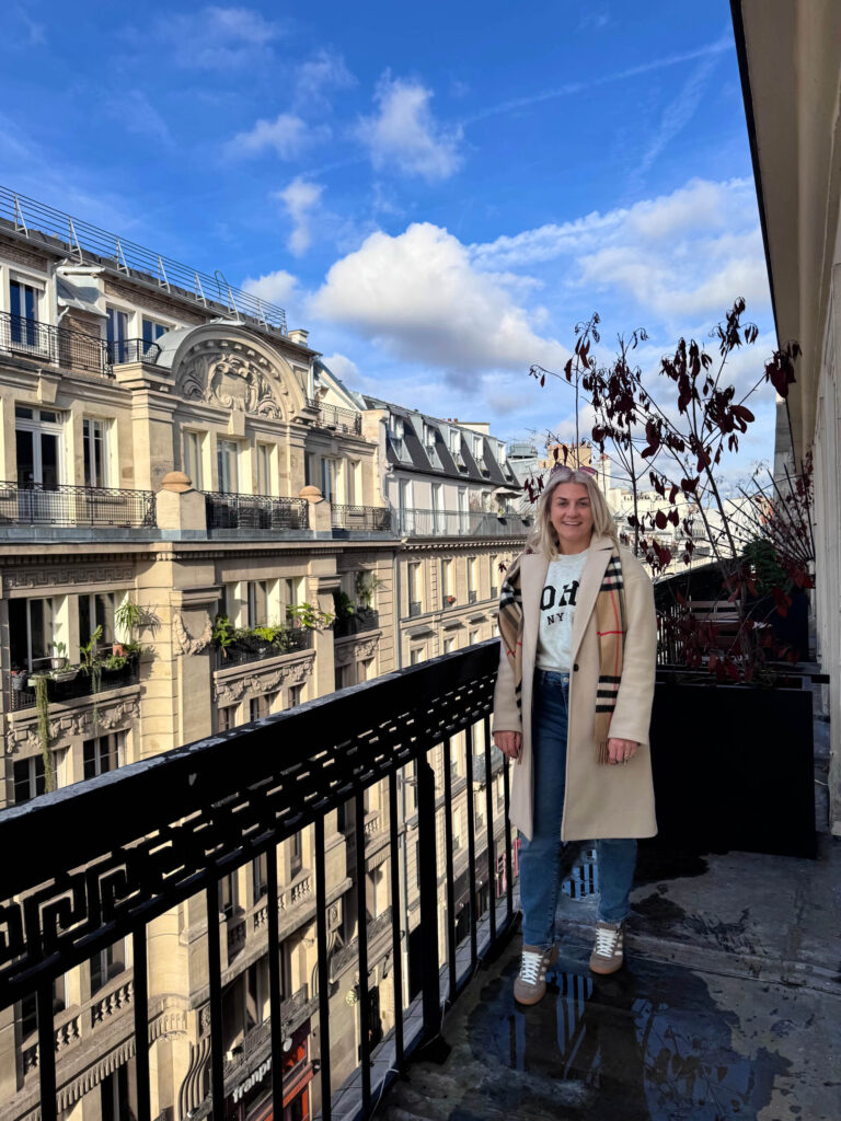 Sam standing on a hotel balcony in Paris.