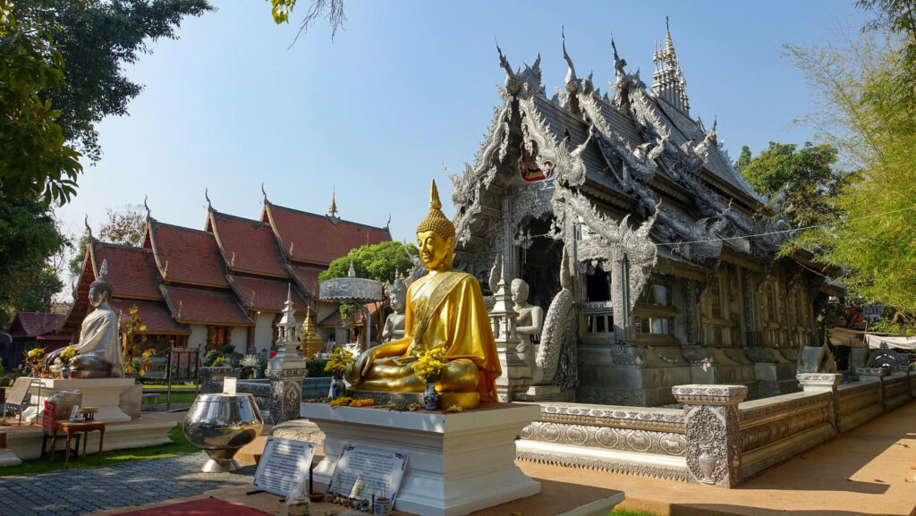 A gold buddha statue and a temple in Chiang Mai, Thailand.