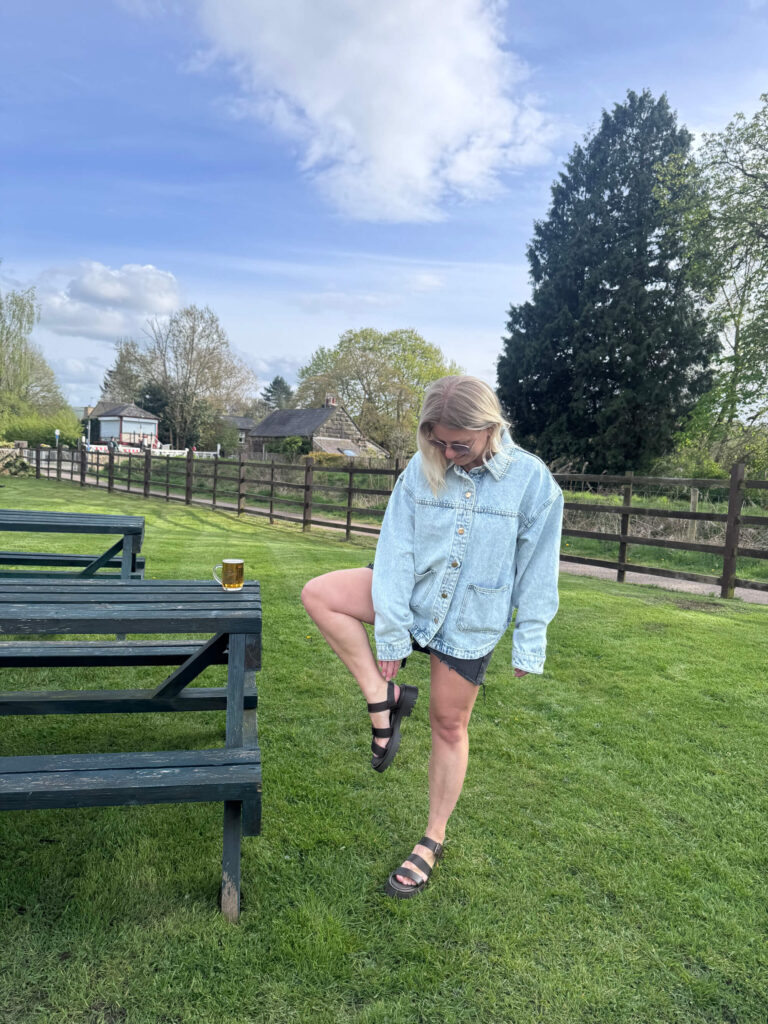 Sam wearing a faded denim jacket and chunky Barbour sandals.