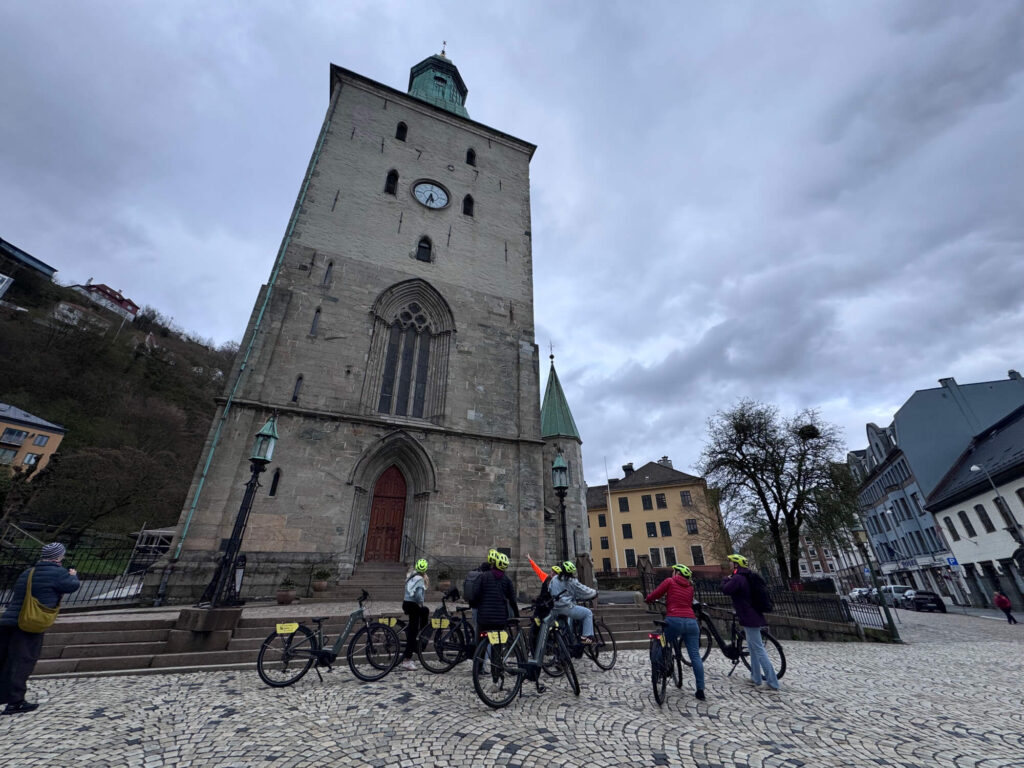 A group on an ebike tour outside Bergen Cathedral.