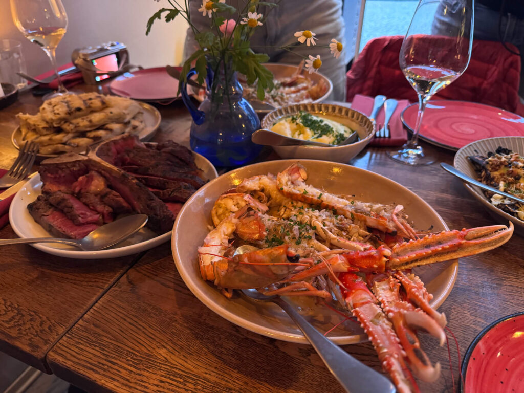 A meal at Allmuen Bistro including langoustines and T-bone steak.