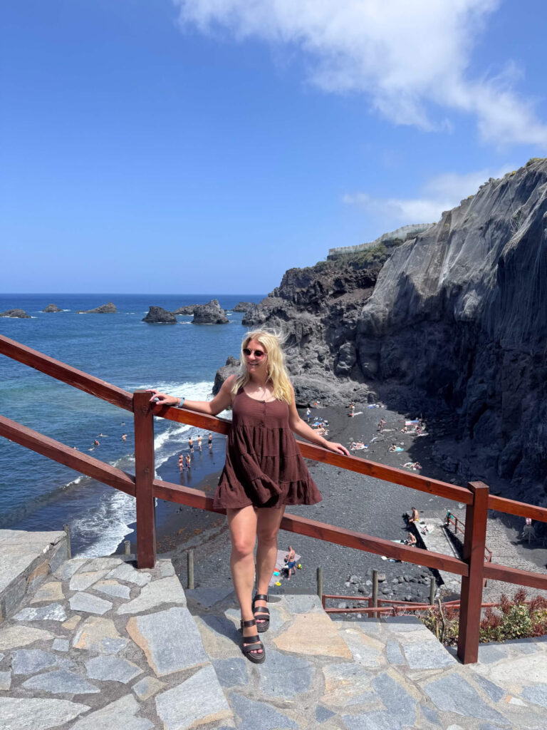 Sam standing in front of a black sand beach in La Palma.